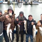 Group of men holding up their fresh catch from the charter boat outing