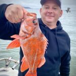 Man holding rock fish he caught