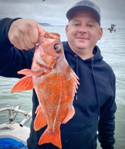 Man holding rock fish he caught